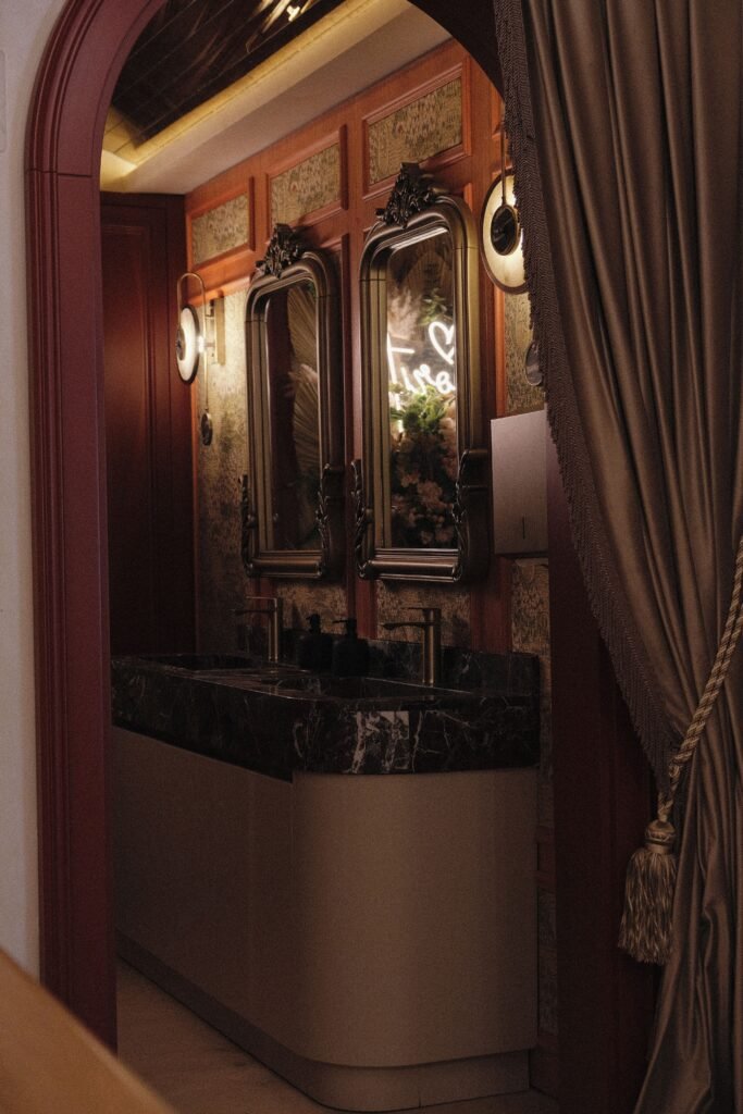 Elegant vintage bathroom interior with ornate mirrors and marble sink.